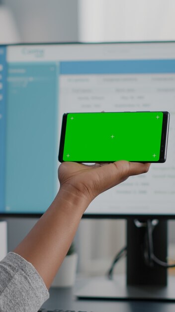 African american student working remote from home looking with mock up green screen