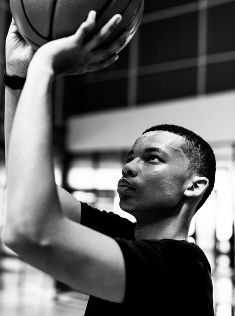 African American teenage boy concentrated on playing basketball