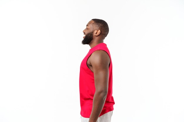 African American teenager shows muscles on arm. Isolated on white background. Studio portrait. Transitional age concept.