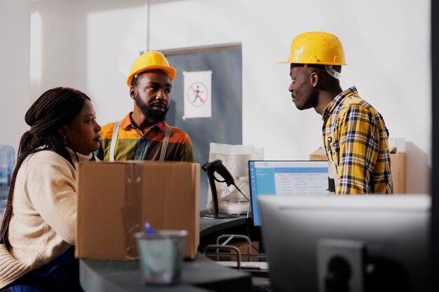 African american warehouse operators discussing shipment managing at work. All black postal storehouse employees team standing at reception desk while planning goods inventory