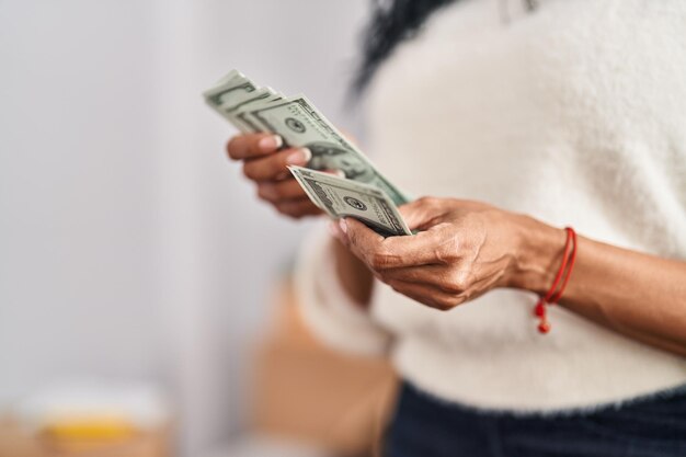 아프리카계 미국인 여성 이 새 집 에서 달러 를 세고 있다