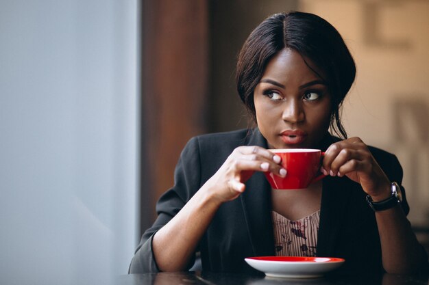 African american woman drinking coffee in a bar