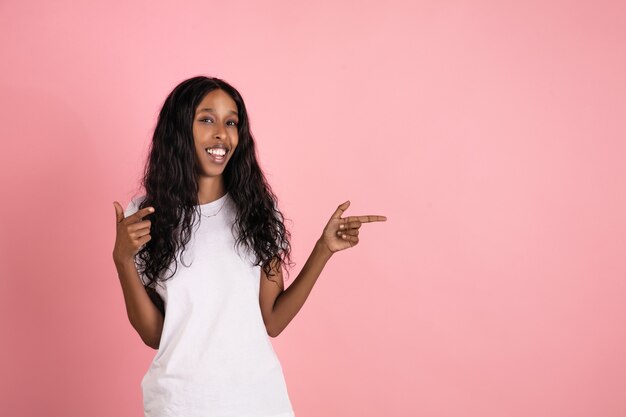 African-american woman isolated on pink wall, copyspace