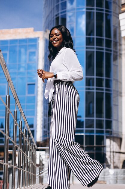 African american woman outdoors by the skyscraper