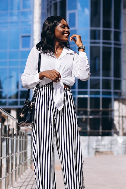 Free photo african american woman outdoors by the skyscraper