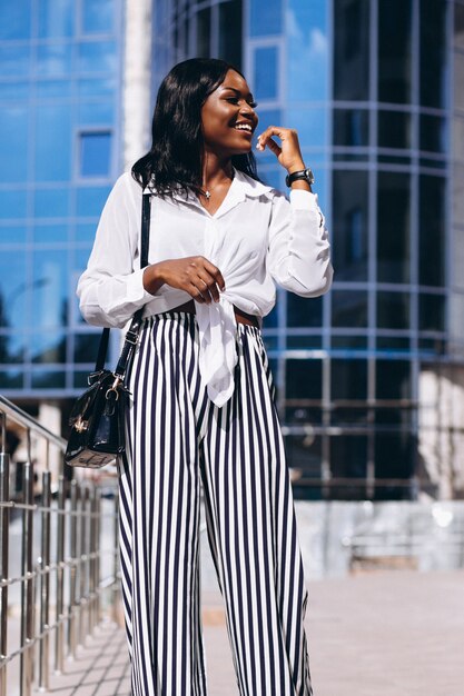 African american woman outdoors by the skyscraper