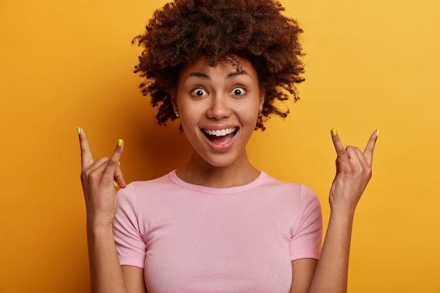 Free photo african american woman punk shows cool rock n roll hand gesture