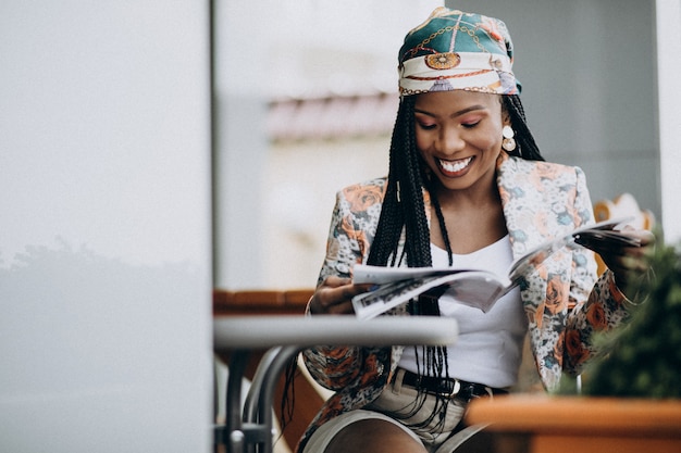 Free photo african american woman reading magazine in a cafe