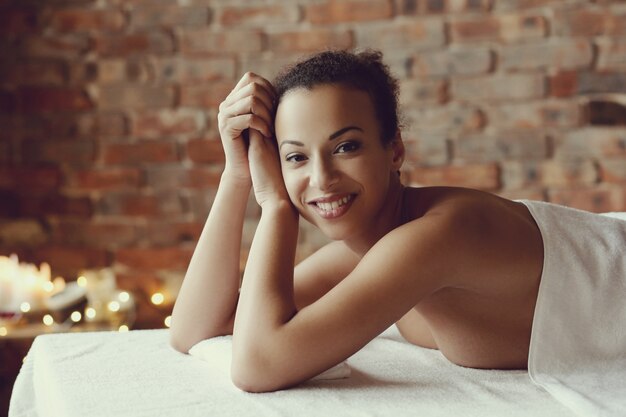 Афро-американская женщина получает расслабляющий массаж в спа-салоне