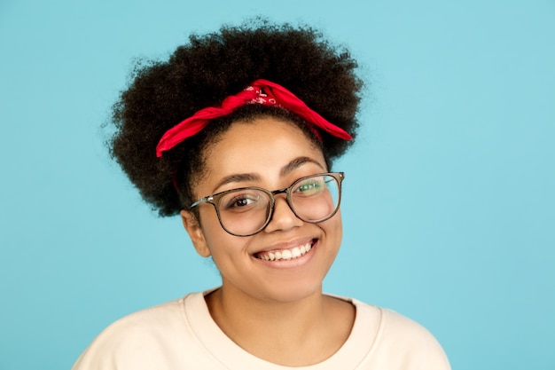 African-american woman's portrait isolated on blue wall with copyspace