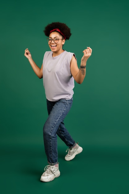 African-american woman's portrait isolated on green wall with copyspace