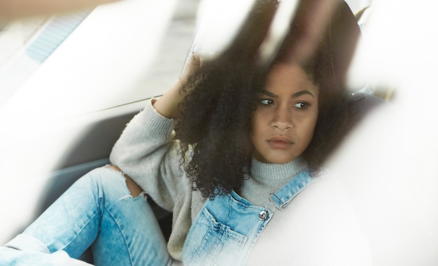 Foto gratuita donna afroamericana seduta in posa all'interno della sua auto