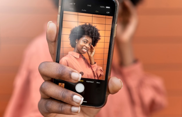 Афро-американская женщина, делающая селфи со своим смартфоном