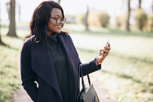 Donna afroamericana parlando al telefono nel parco