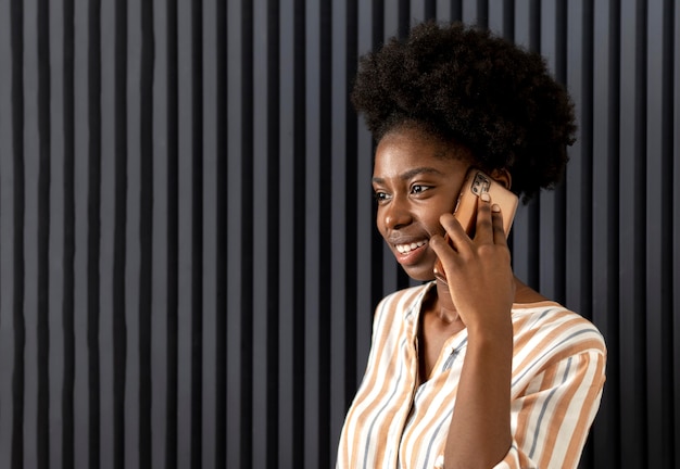 Афро-американская женщина разговаривает с кем-то на своем смартфоне