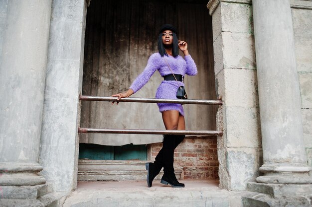 African american woman at violet dress and cap posed outdoor