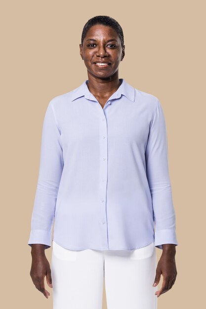 Афро-американская женщина в синей рубашке с длинным рукавом с белыми брюками