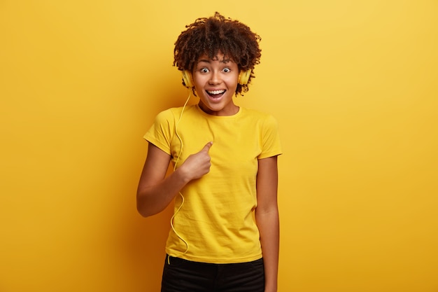 노란색 티셔츠와 헤드폰을 착용하는 아프리카 계 미국인 여자