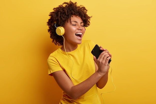 African American woman wearing yellow T-shirt and headphones