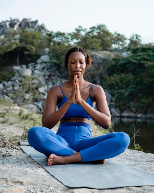Афро-американский учитель йоги, практикующий на открытом воздухе