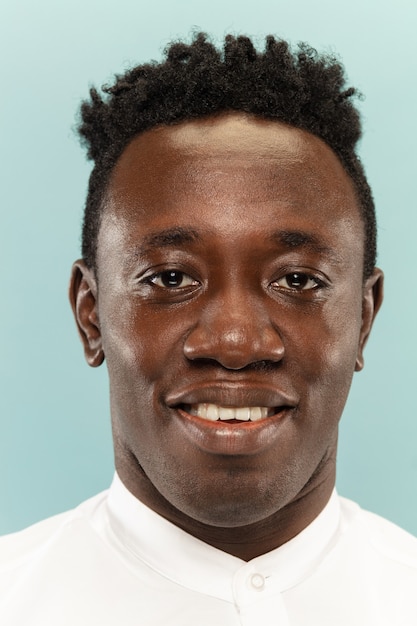 Free photo african-american young man's close up portrait on blue background