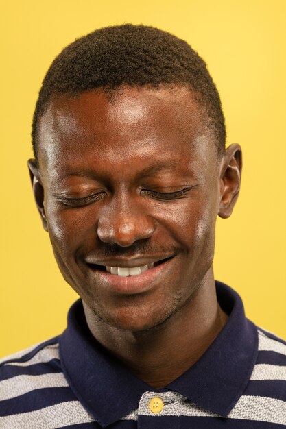 African-american young man's close up portrait on blue studio