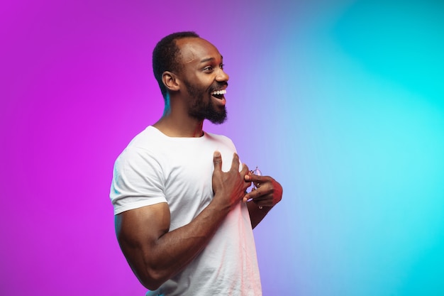 African-american young man's portrait on gradient studio in neon