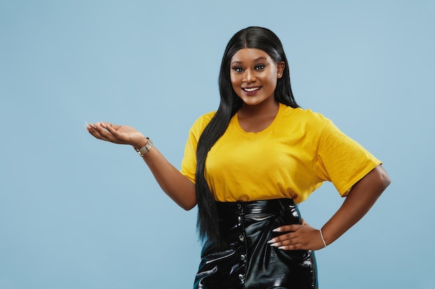 African-american young woman's half-length portrait on blue studio