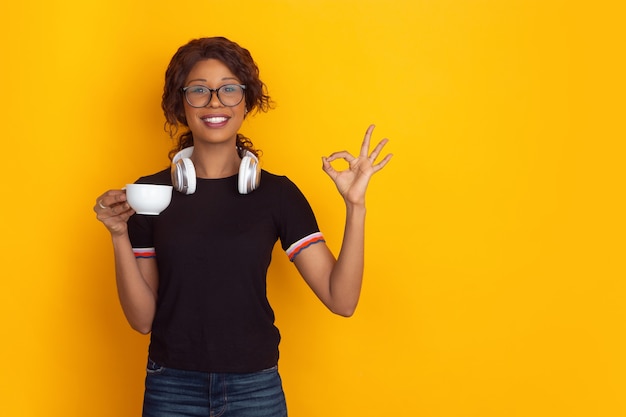 African-american young woman's portrait isolated on yellow