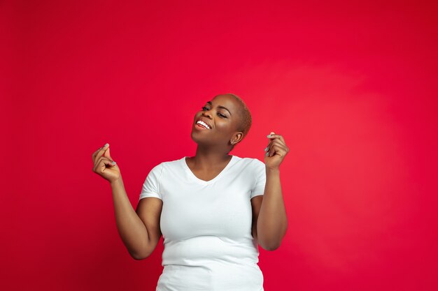 Портрет афро-американской молодой женщины на красном фоне