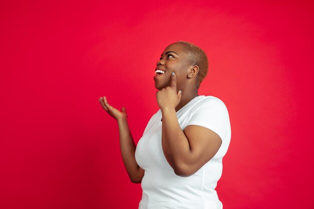 African-american young woman's portrait on red wall