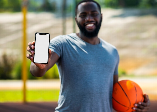 Африканский баскетболист, показывая свой телефон