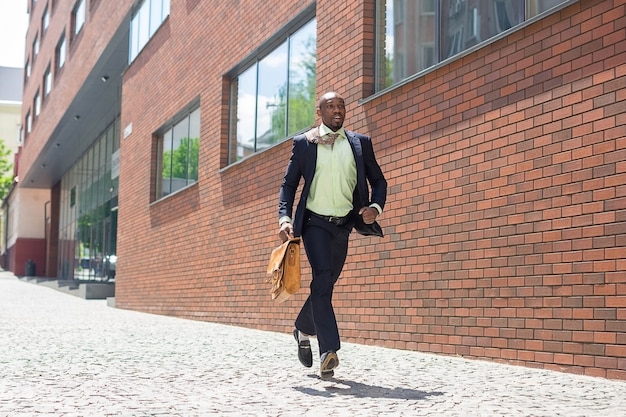 African black young businessman running in a city street