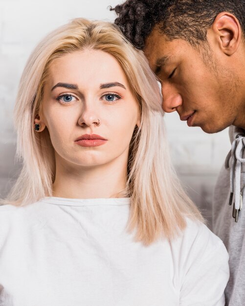 An african boyfriend leaning on her girlfriend's head