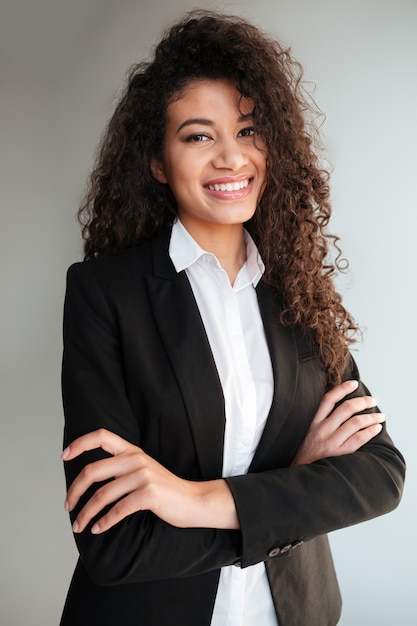 Foto gratuita signora africana di affari che controlla fondo grigio.