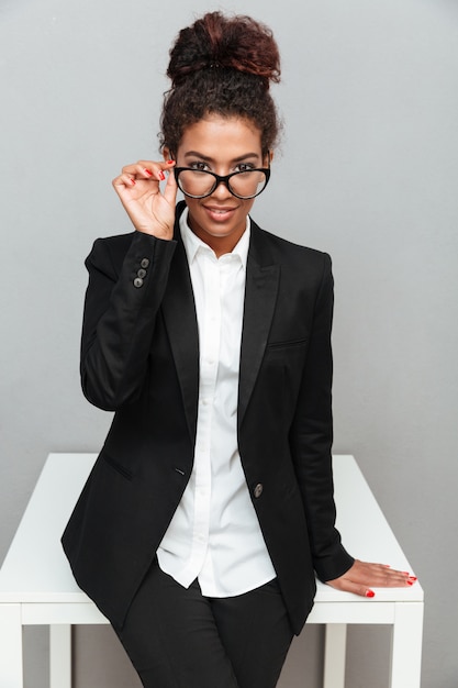 African business woman over grey wall looking