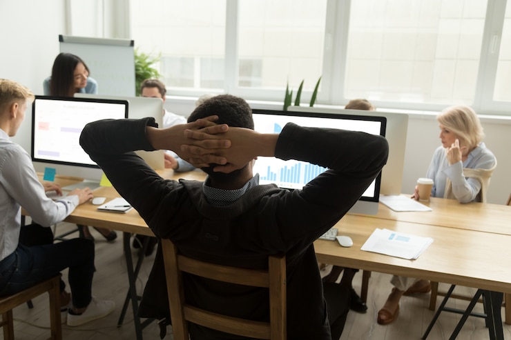 Free Photo african businessman analyzing statistics data in multiracial office, rear view