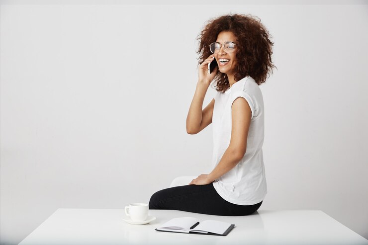 Free Photo african businesswoman laughing speaking on phone at workplace.
