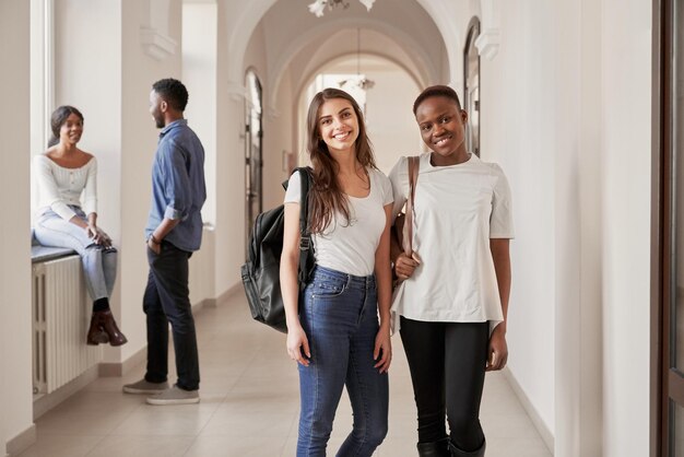 廊下で休んでいるアフリカ人と白人の女子学生
