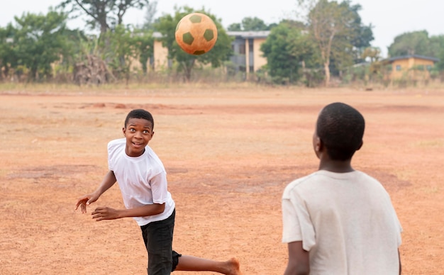 サッカーボールを持つアフリカの子供たち プレミアム写真