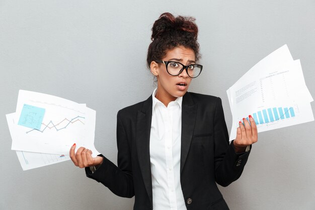 African confused business woman with diagramas documents