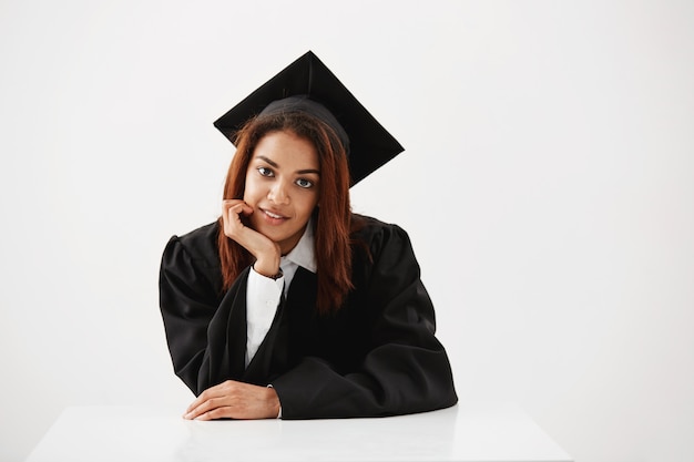 african female graduate smiling sitting.