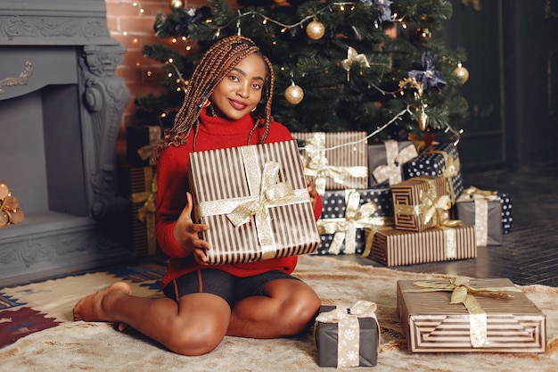 African girl in a Christmas decorations/ Woman in a red sweater. New Year concept.