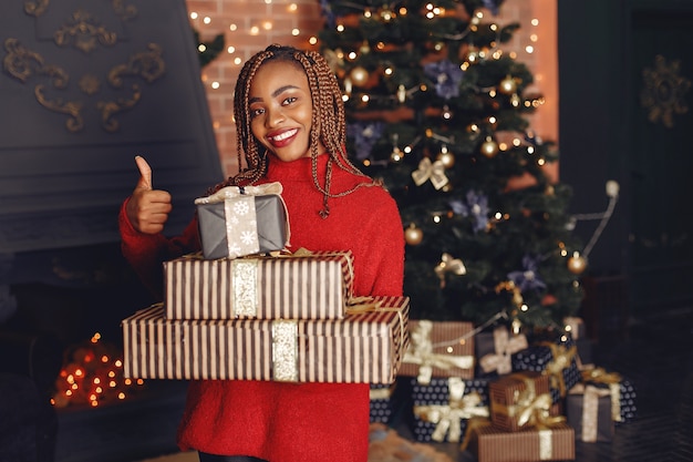 Free photo african girl in a christmas decorations/ woman in a red sweater. new year concept.