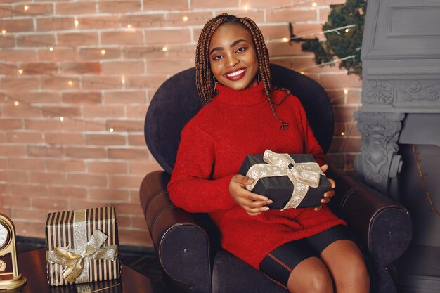 African girl in a Christmas decorations/ Woman in a red sweater. New Year concept.