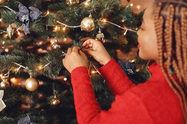 クリスマスの飾り付けのアフリカの女の子/赤いセーターの女性。新年のコンセプト。