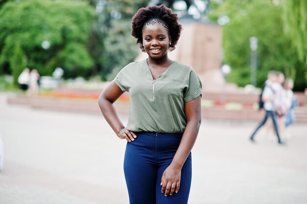 African girl posed at street of city wear on green blouse and blue pants