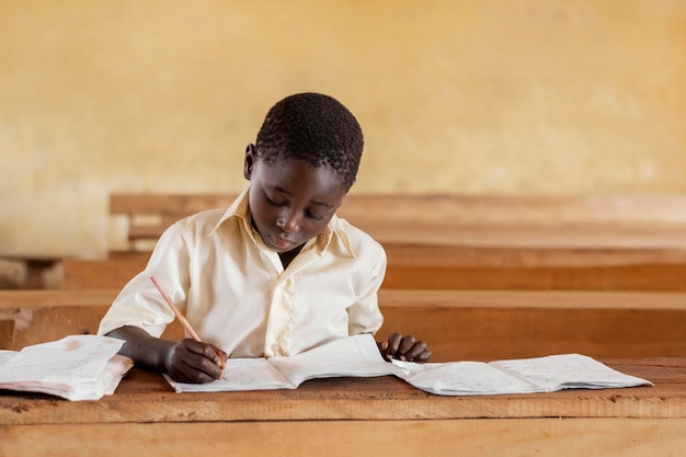 Foto gratuita bambino africano che impara in classe