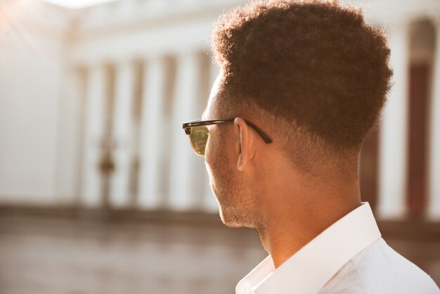 African man early morning looking aside outdoors.