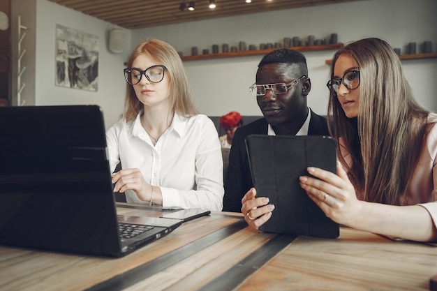 Uomo africano. ragazzo in abito nero. studenti con un laptop. ragazza in camicetta bianca.